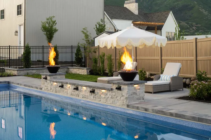 View of pool with patio surround, a fire pit, and a fenced backyard