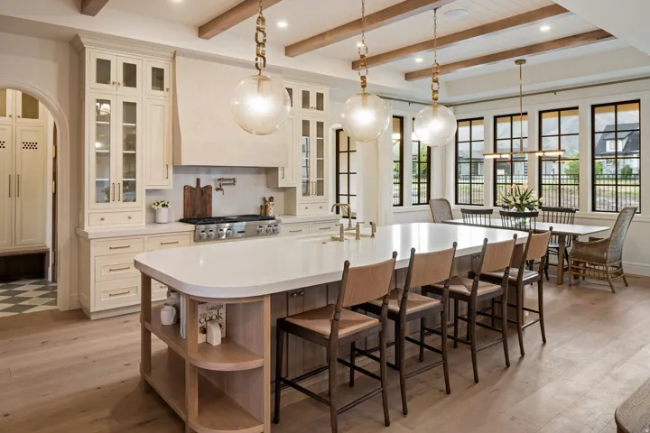 Kitchen with glass insert cabinets, pendant lighting, light wood-style flooring, and beam ceiling