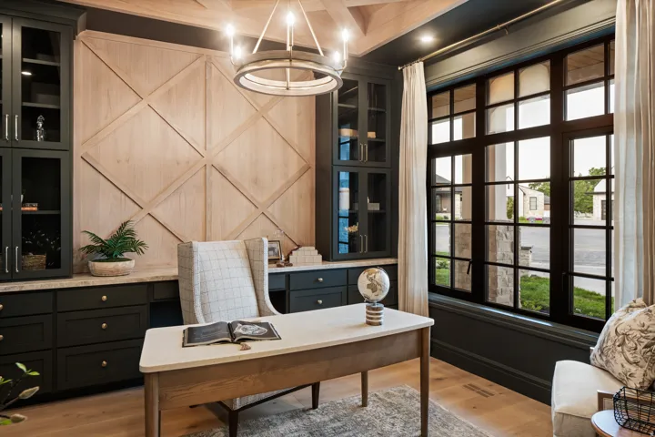 Office space with light wood-type flooring and suspended lighting