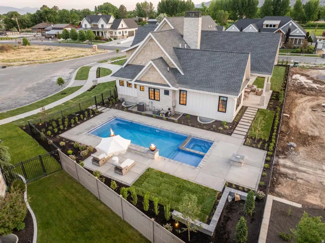 Relaxing pool / spa featuring a fenced backyard, a patio area, and a residential view