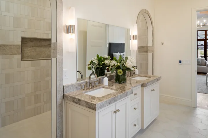 Full bath featuring ensuite bath, double vanity, light tile patterned floors, and a walk in shower