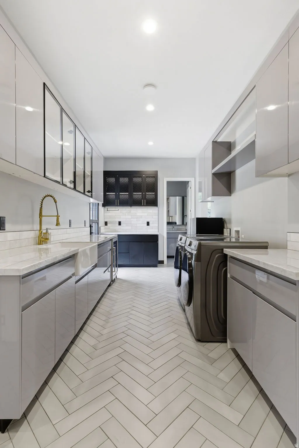 Laundry area featuring herringbone tile flooring, recessed lighting, white stone countertops, and light gray cabinetry