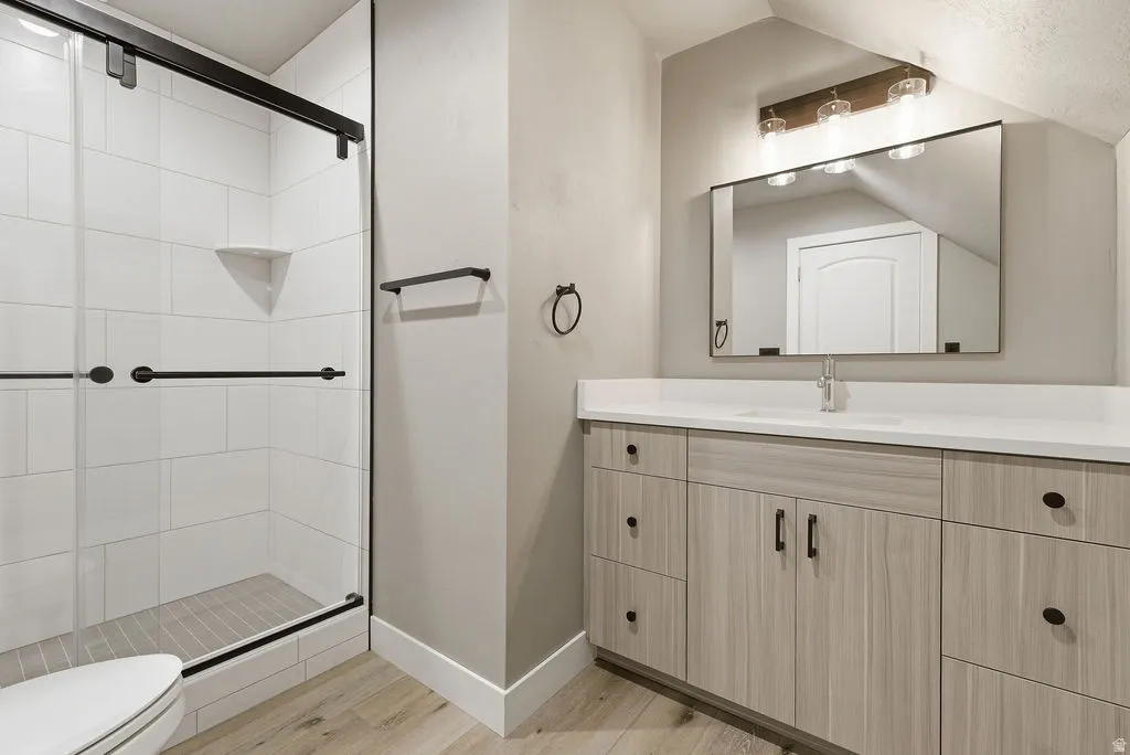 Modern bathroom featuring a spacious walk-in shower with black-framed glass doors, white tiled walls, and a built-in corner shelf