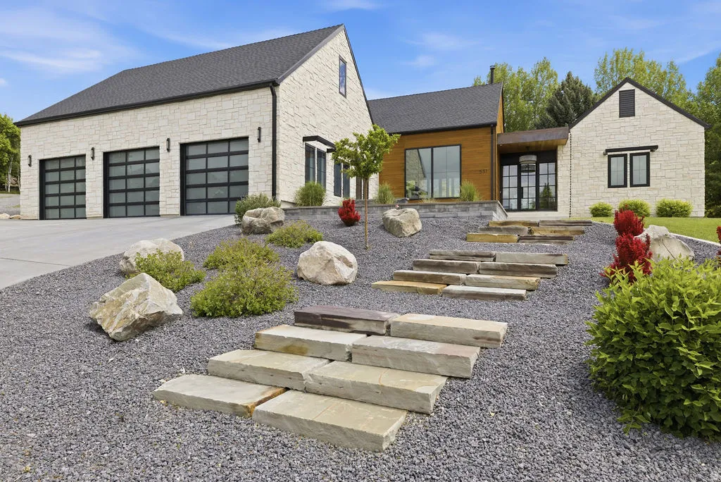 Modern exterior featuring light-colored stone siding, a dark roof, and wood-finish paneling