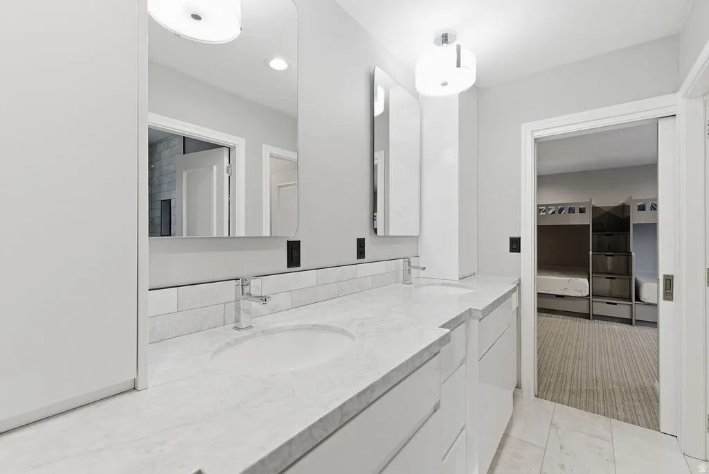 Dual vanity with undermount sinks, stone countertops, and chrome fixtures