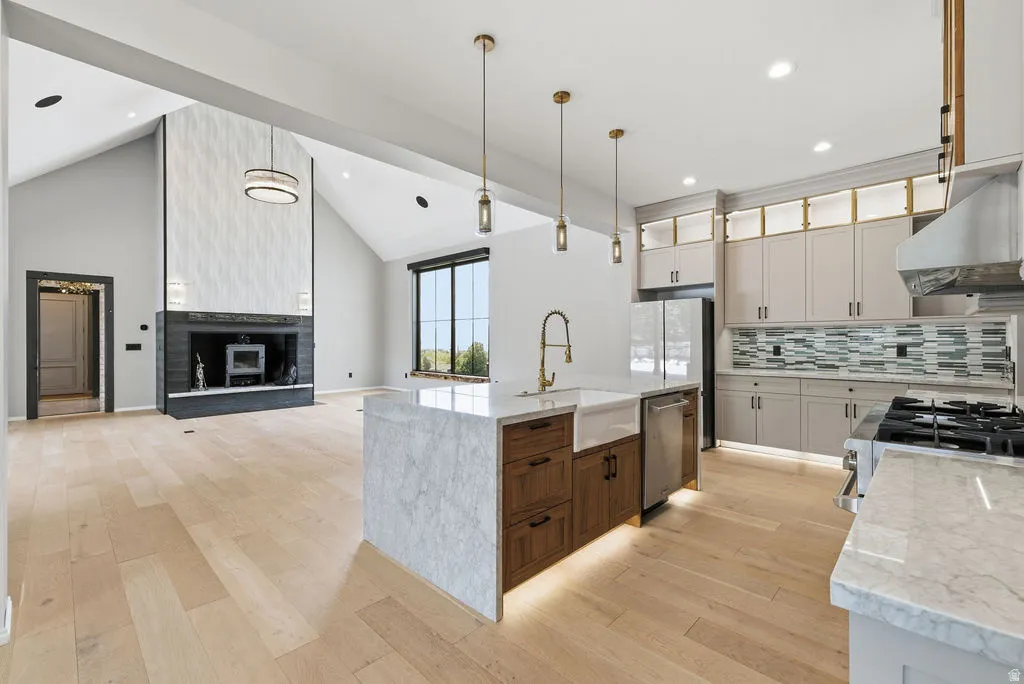 Kitchen island with marble-finish countertop, farmhouse sink, and brass-finish faucet