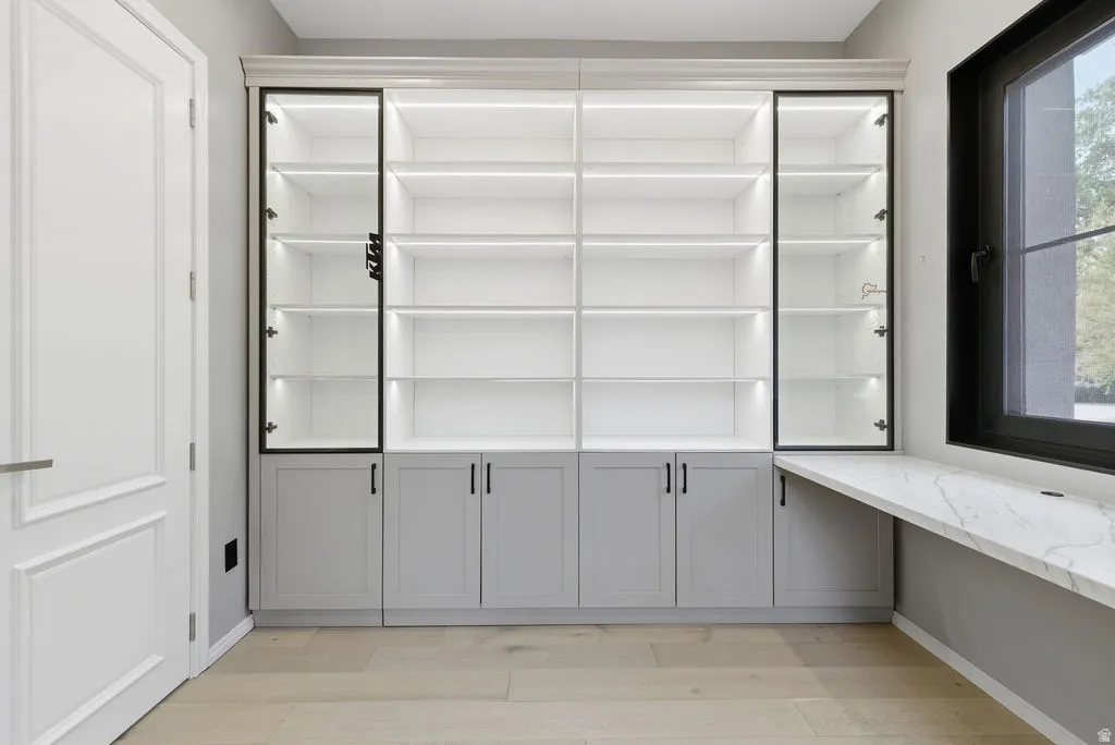 Custom built-in shelving with integrated lighting and glass-front display cabinets