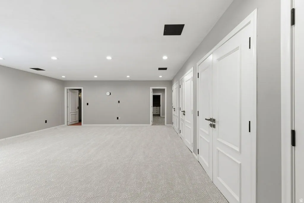 Spacious room featuring light gray walls and recessed lighting