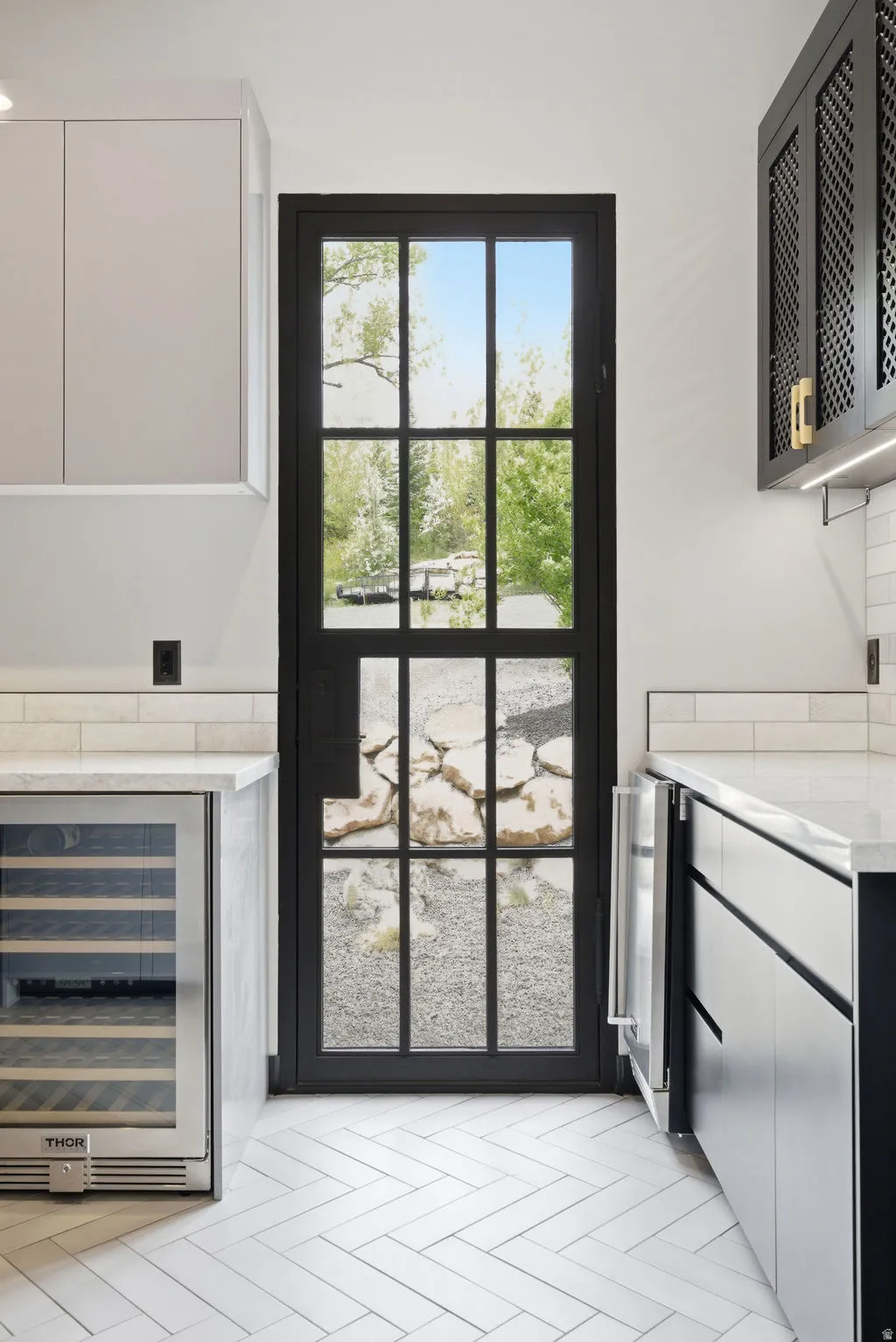 Black-framed glass-paneled door opening to an outdoor area