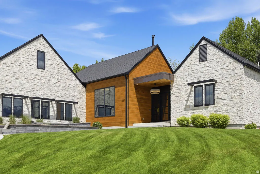 Contemporary exterior featuring a combination of light-colored stone veneer and warm wood siding