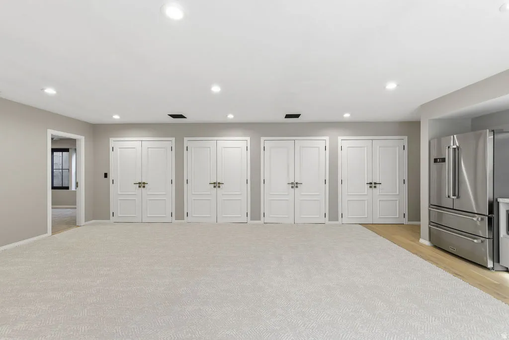 Spacious interior with neutral-toned walls, recessed lighting, and light-colored carpeting