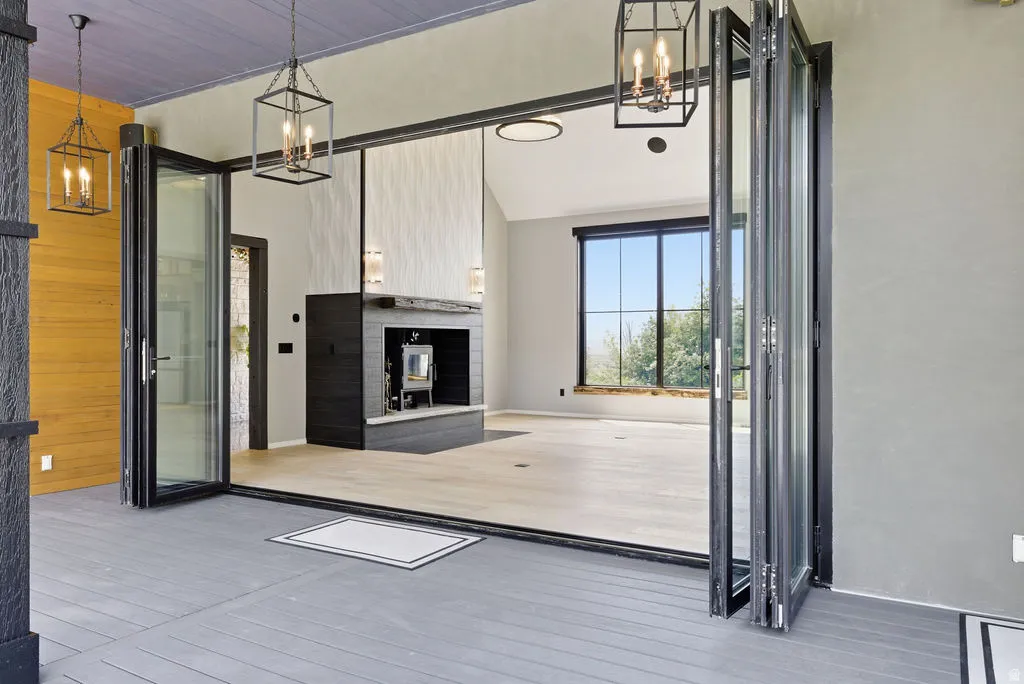 Expansive bi-fold glass doors opening to a covered porch with plank flooring