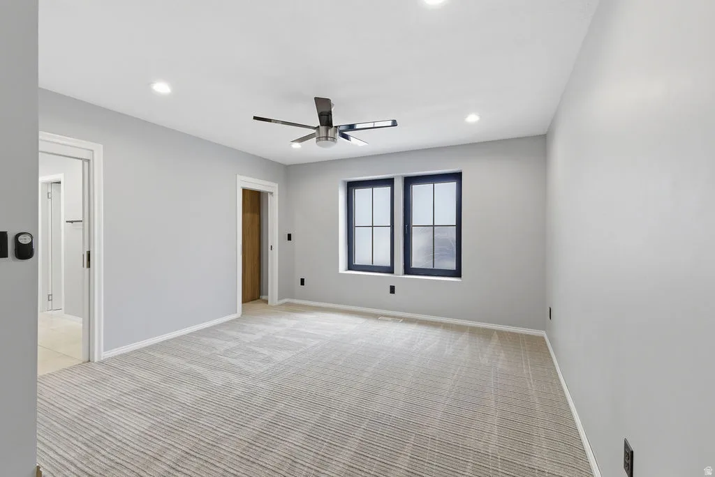 Spacious room featuring light gray walls and a patterned carpet