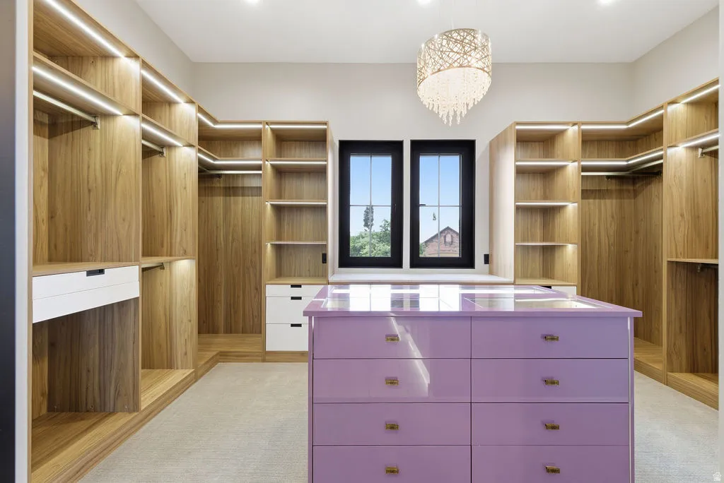 Custom walk-in closet featuring extensive built-in wood-finish shelving and hanging space with integrated lighting