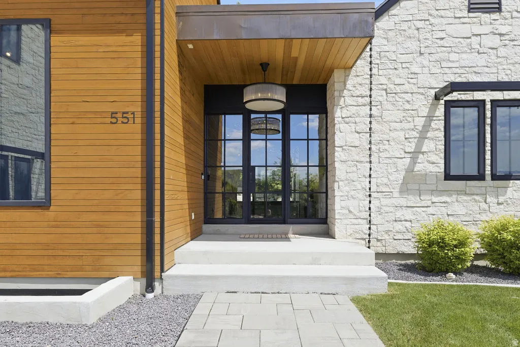 Modern exterior featuring warm wood-finish siding and light-toned stone masonry