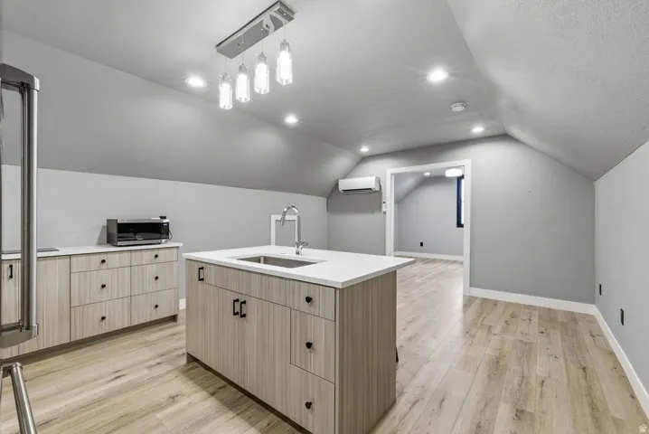 Kitchen area featuring light wood-finish flooring and sloped ceilings