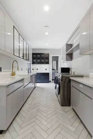 Laundry area featuring herringbone tile flooring, recessed lighting, white stone countertops, and light gray cabinetry