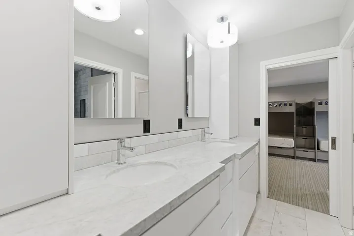 Dual vanity with undermount sinks, stone countertops, and chrome fixtures