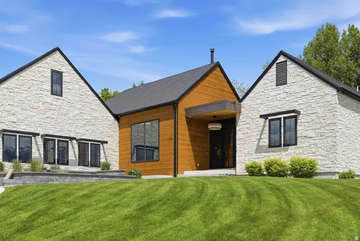 Contemporary exterior featuring a combination of light-colored stone veneer and warm wood siding