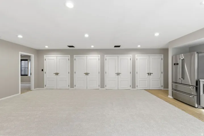 Spacious interior with neutral-toned walls, recessed lighting, and light-colored carpeting