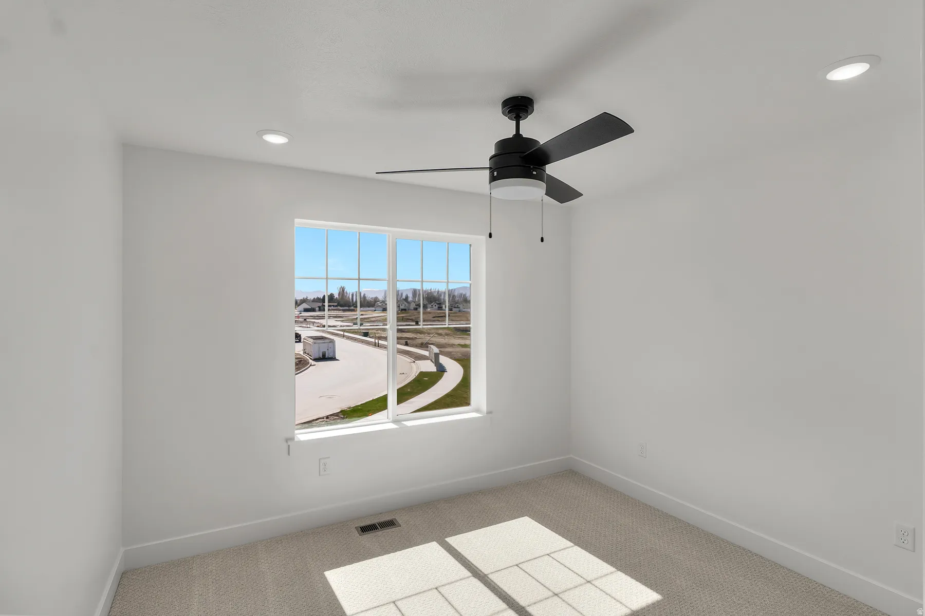 Bright room with a large window, recessed lighting, a ceiling fan, light-toned carpeting, and white walls