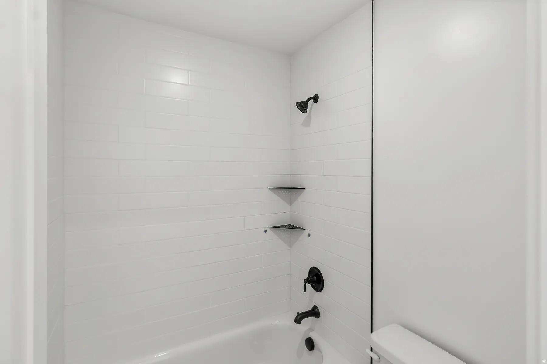Bathroom featuring a white subway tile shower surround with integrated corner shelves