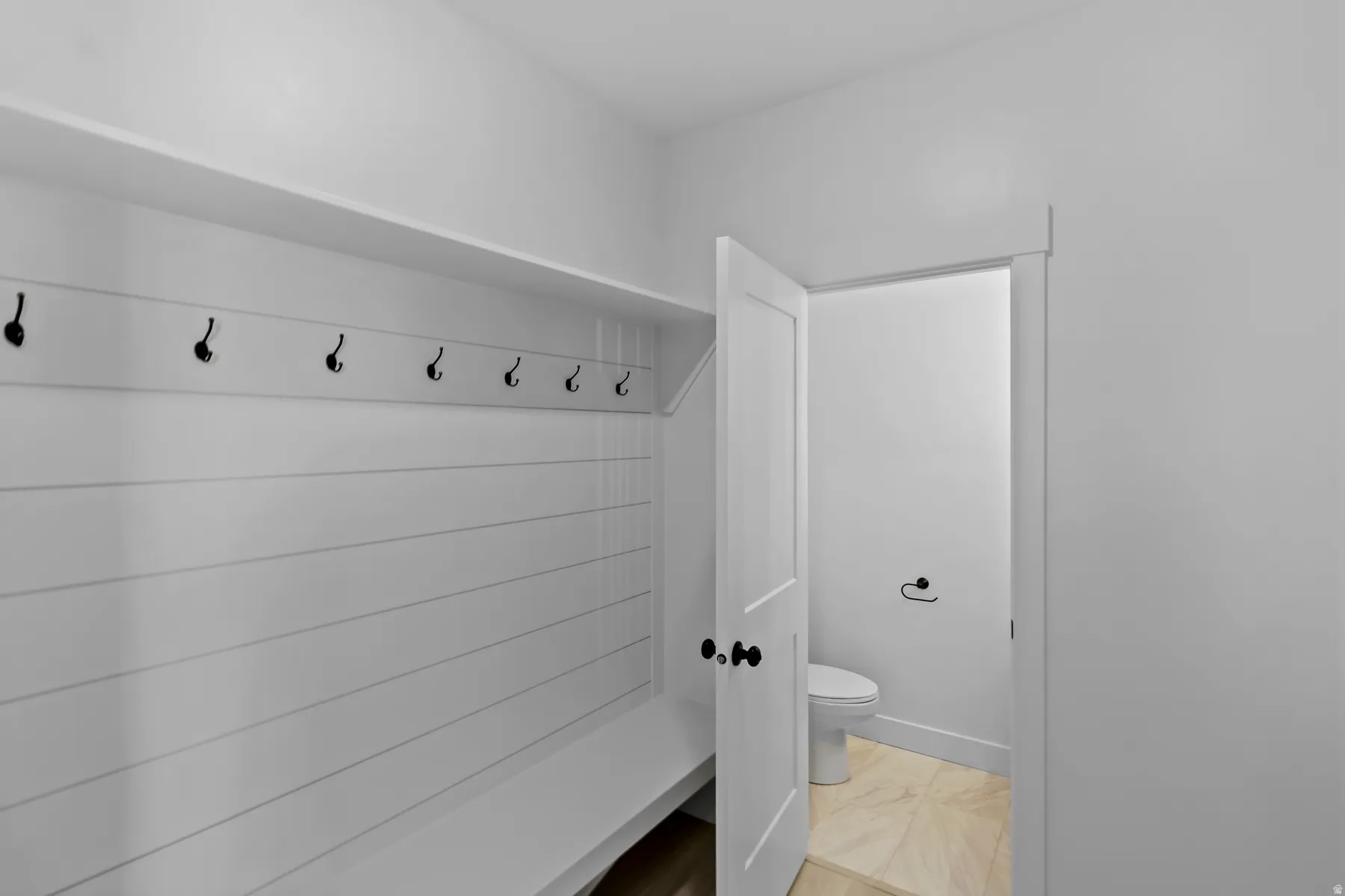Built-in bench with shiplap backing and black coat hooks