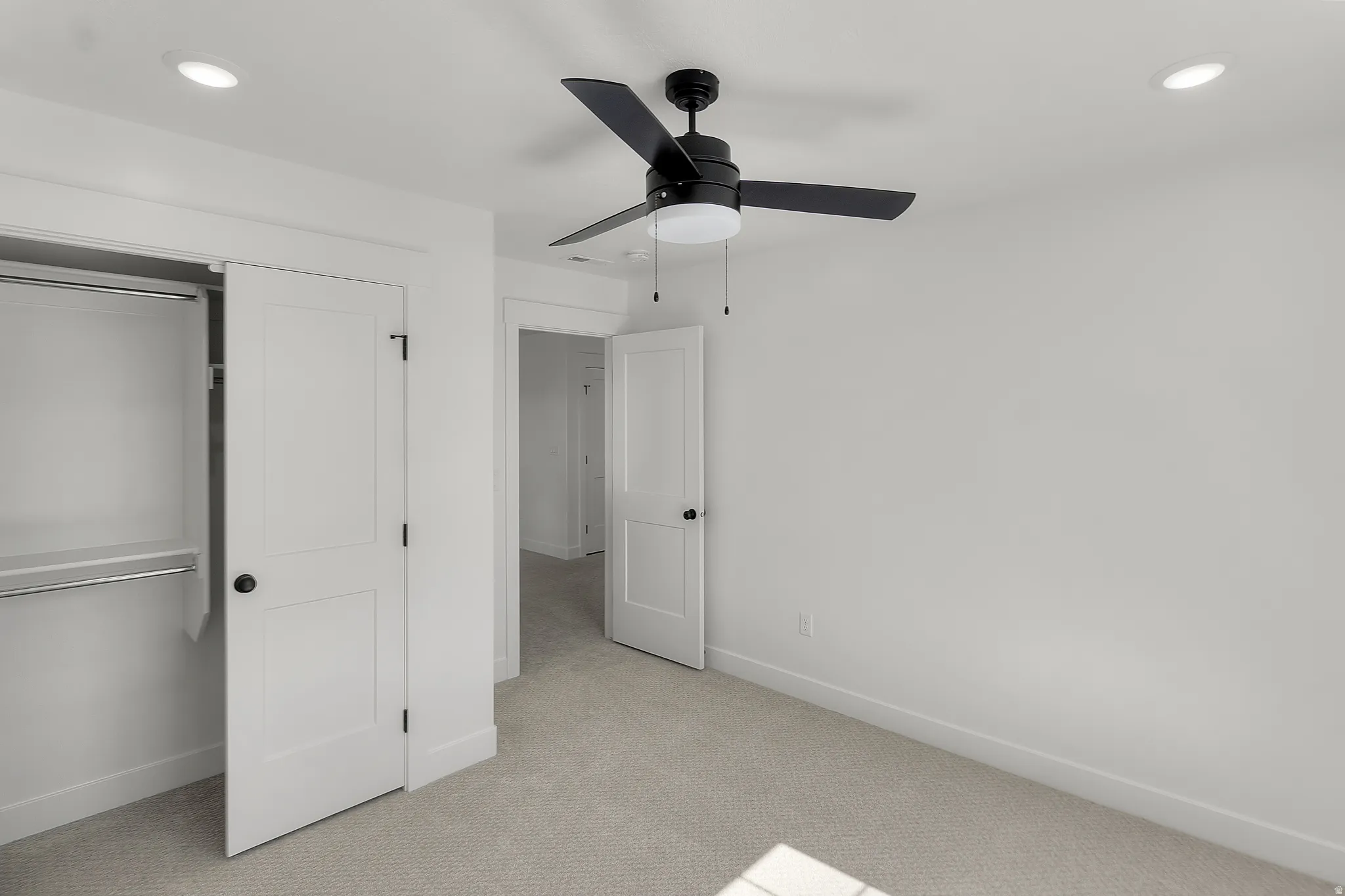 Bedroom featuring light-toned carpeting, a ceiling fan with integrated lighting, recessed ceiling lights, and a closet with a built-in hanging rod and shelf