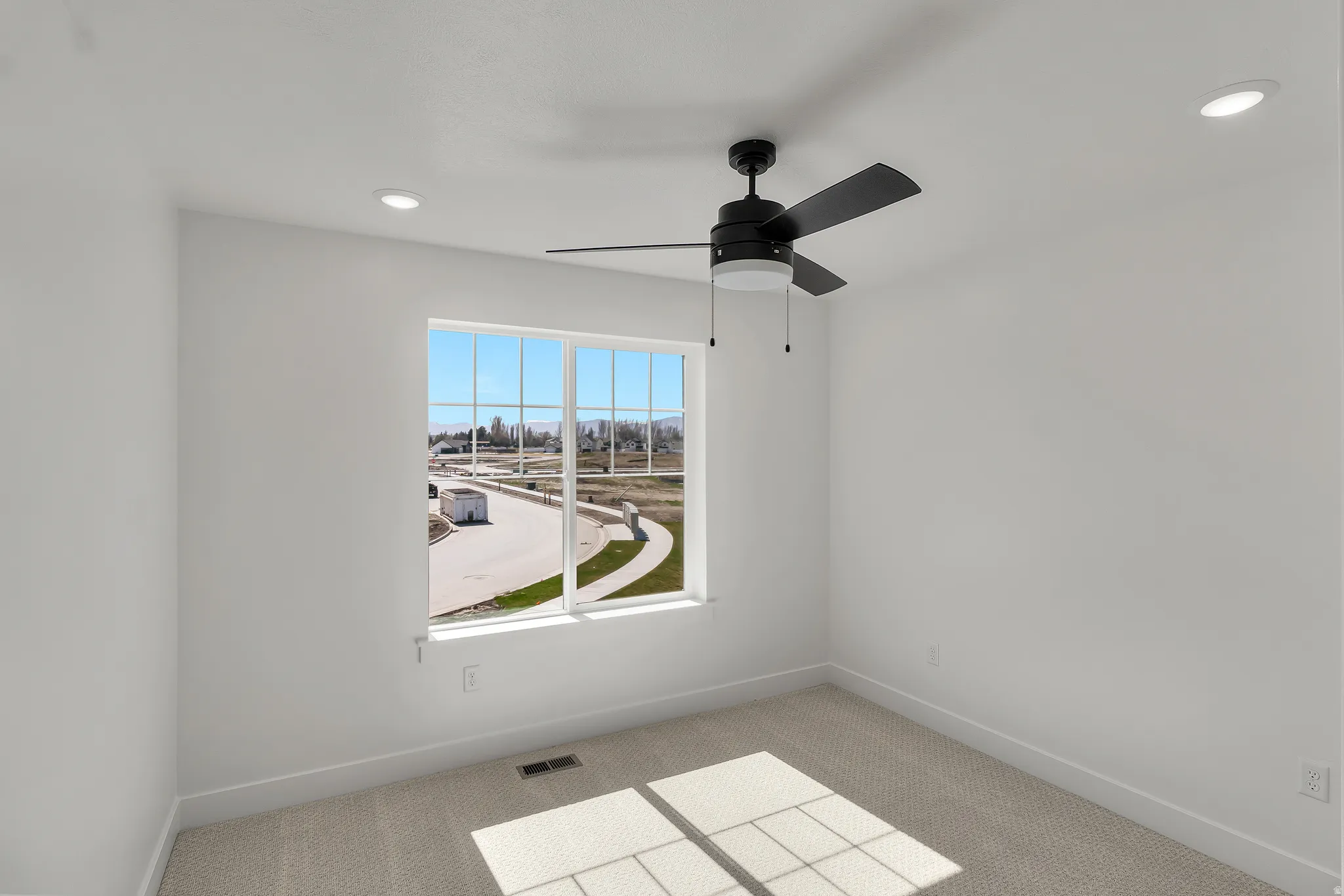 Bright room with a large window, recessed lighting, and a ceiling fan