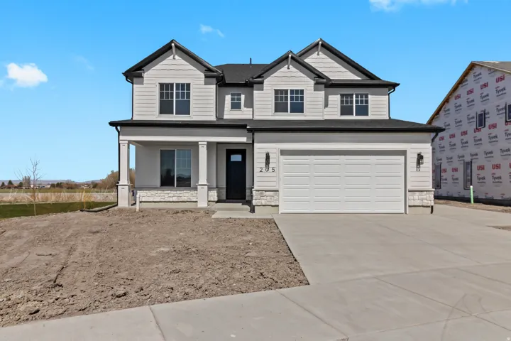 Modern farmhouse exterior featuring light siding, dark trim, and a covered porch with square columns