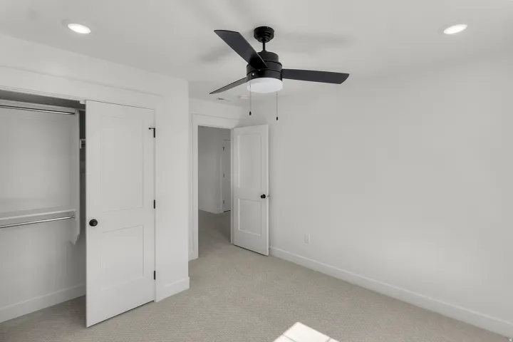 Bedroom featuring light-toned carpeting, a ceiling fan with integrated lighting, recessed ceiling lights, and a closet with a built-in hanging rod and shelf