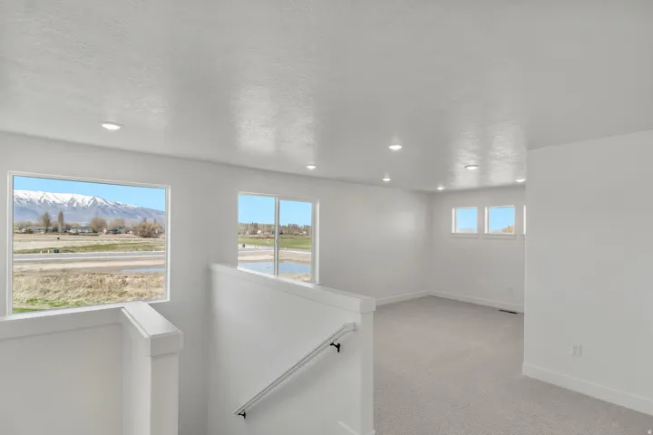 Spacious interior featuring a carpeted floor, recessed lighting, and multiple windows offering mountain and landscape scenery