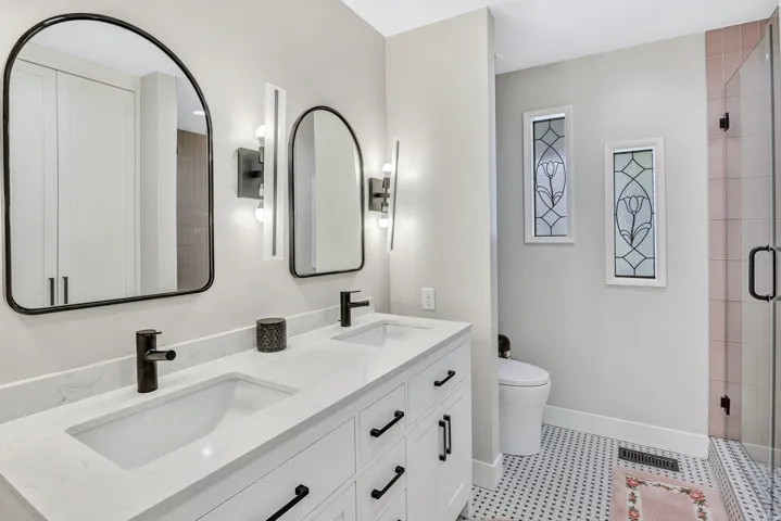 Double vanity featuring quartz countertops, undermount sinks, and matte black fixtures
