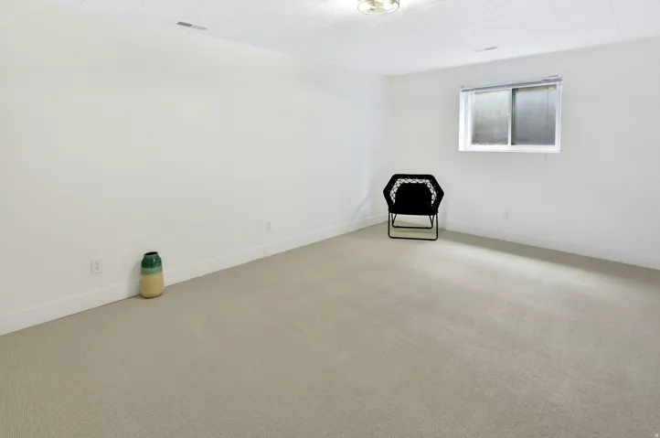 Spacious room with light-toned carpeting and neutral white walls