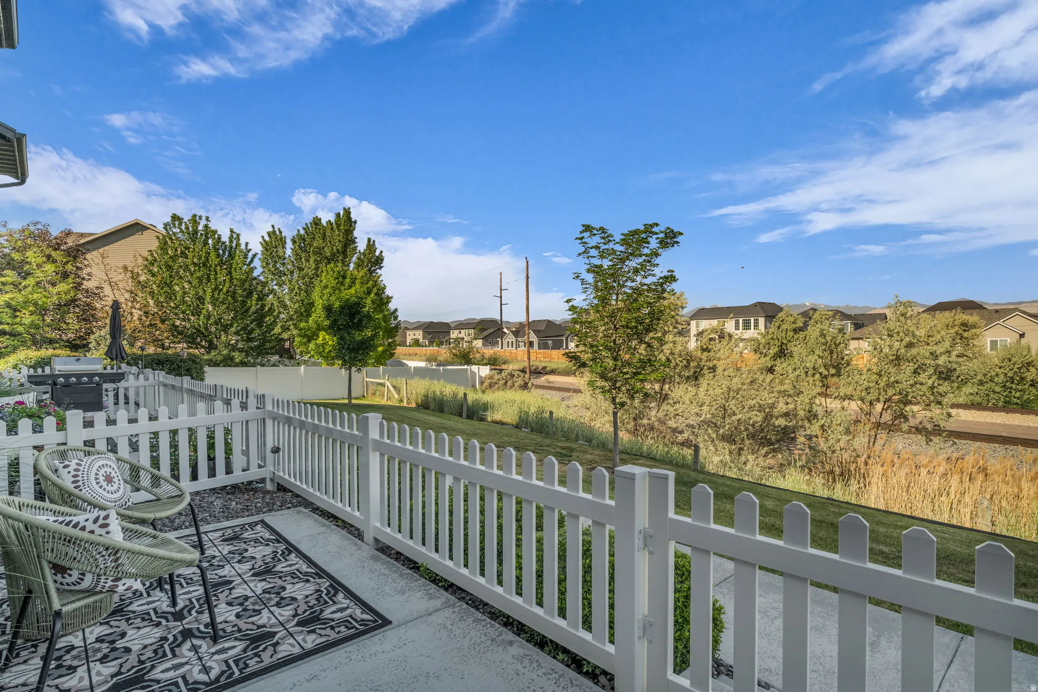 Concrete patio featuring a white picket fence
