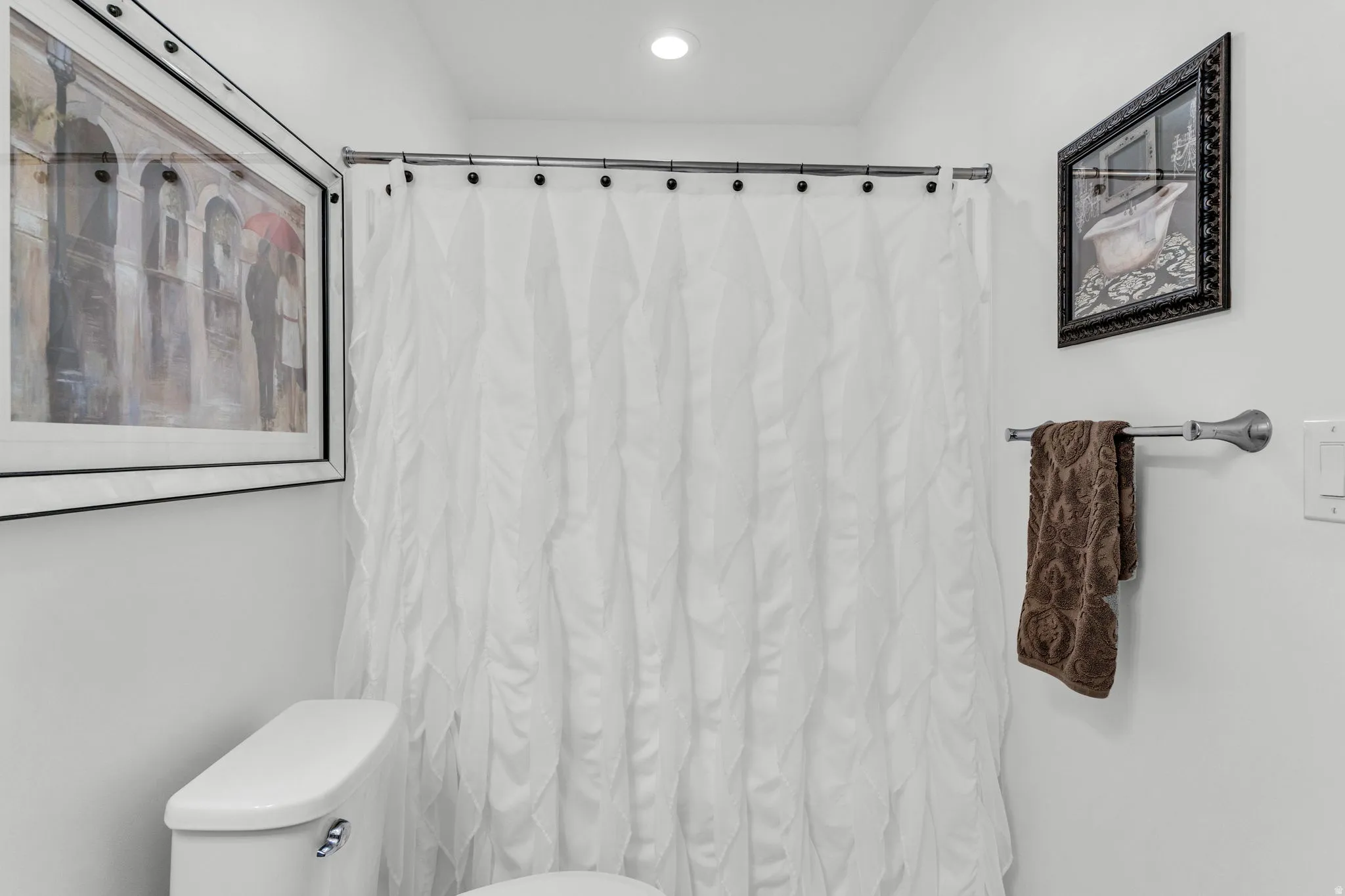 Compact bathroom featuring a white toilet, recessed lighting, white walls, and a shower with a textured white curtain