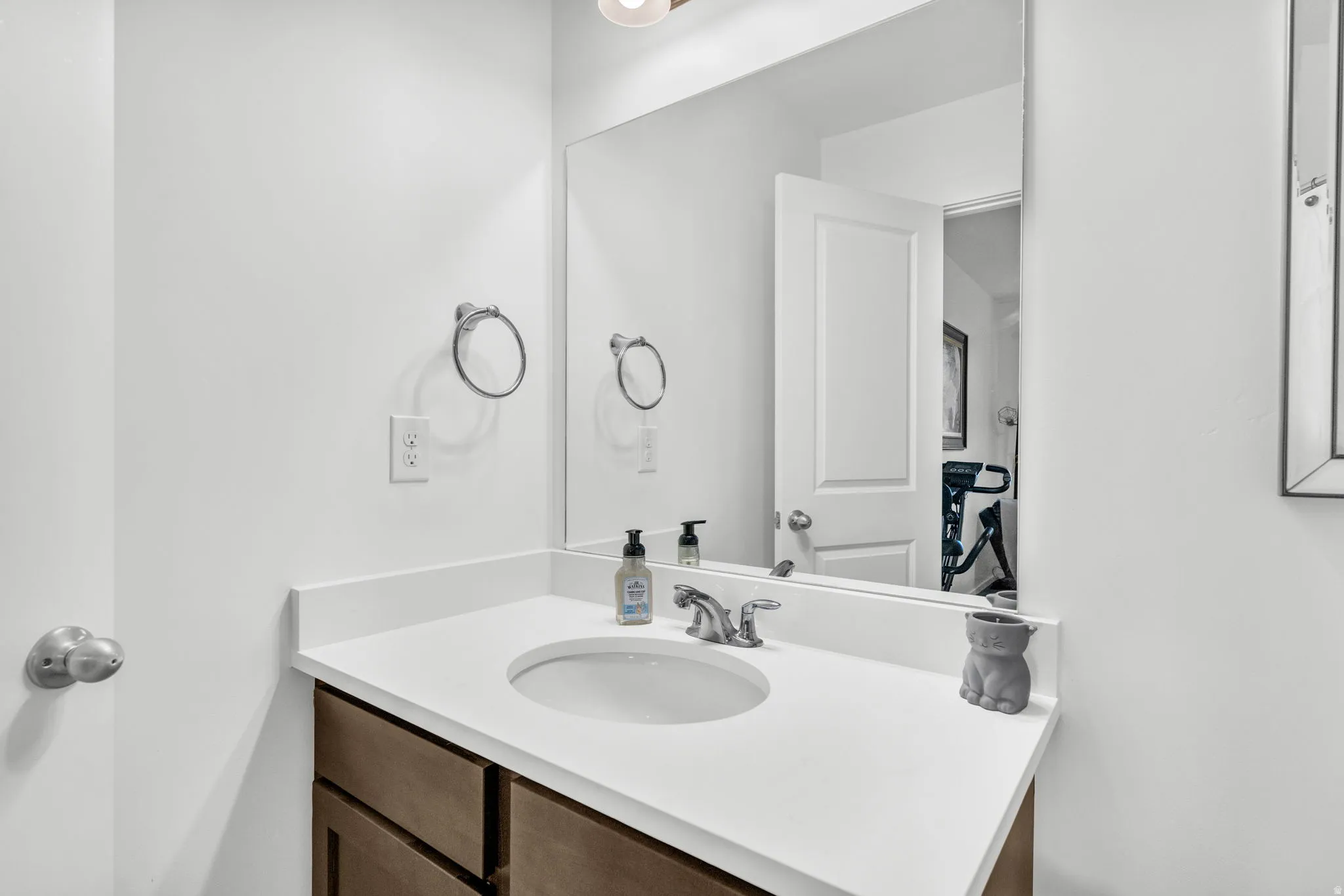 Bathroom vanity featuring a light-toned countertop with an integrated sink and a chrome-finish faucet
