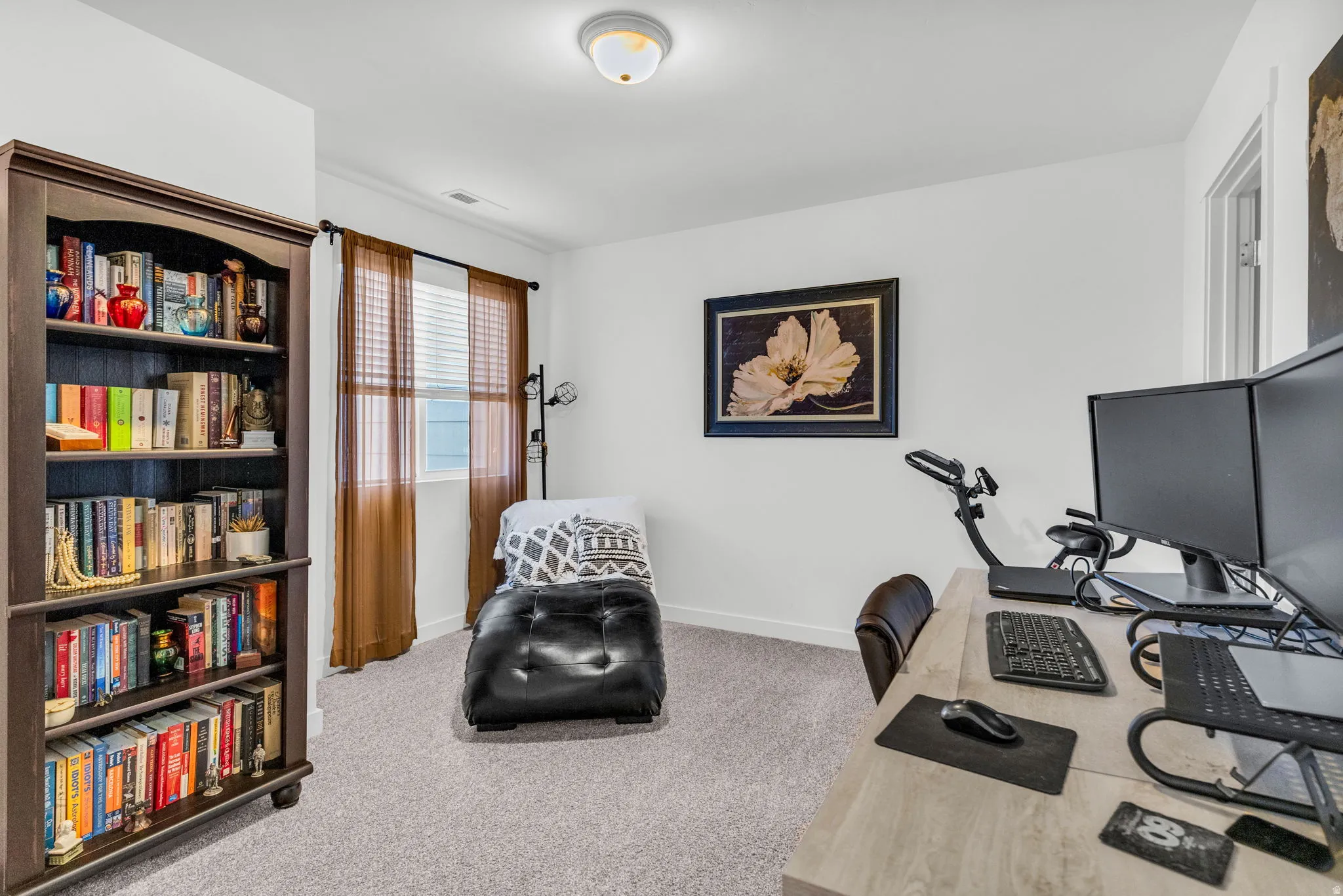 Carpeted room featuring a built-in bookcase, a window with blinds, and white walls