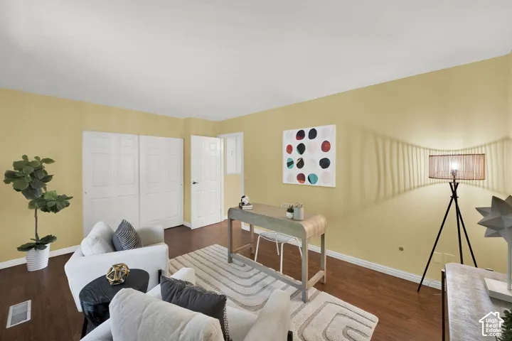 Spacious room featuring wood-finish flooring, light-toned walls, and white baseboards