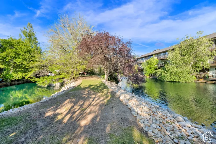 Waterfront setting featuring a natural rock embankment and surrounding green space