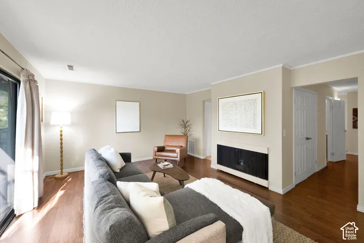 Living room featuring wood-finish flooring, light neutral wall paint, and white trim