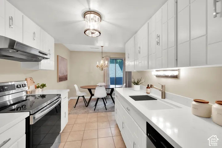Kitchen featuring white cabinetry, integrated sink, stainless steel appliances, and tile flooring