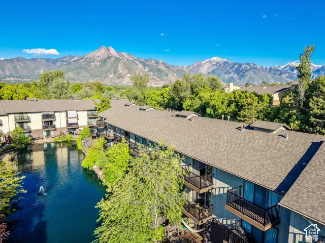 Multi-level residential buildings featuring private balconies and a central pond with a fountain