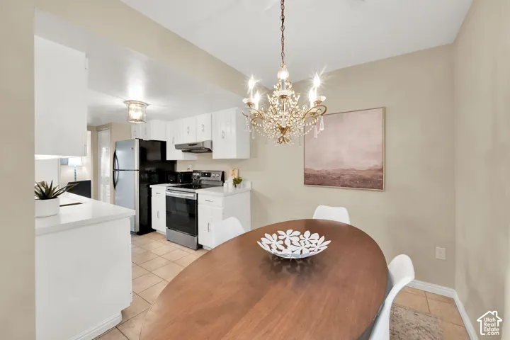 Dining area featuring a chandelier with crystal accents and tile flooring