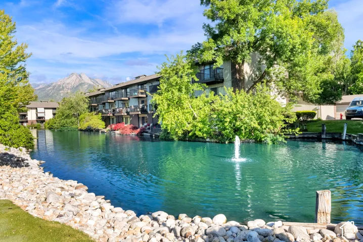 Waterfront building with private balconies and a mountain backdrop