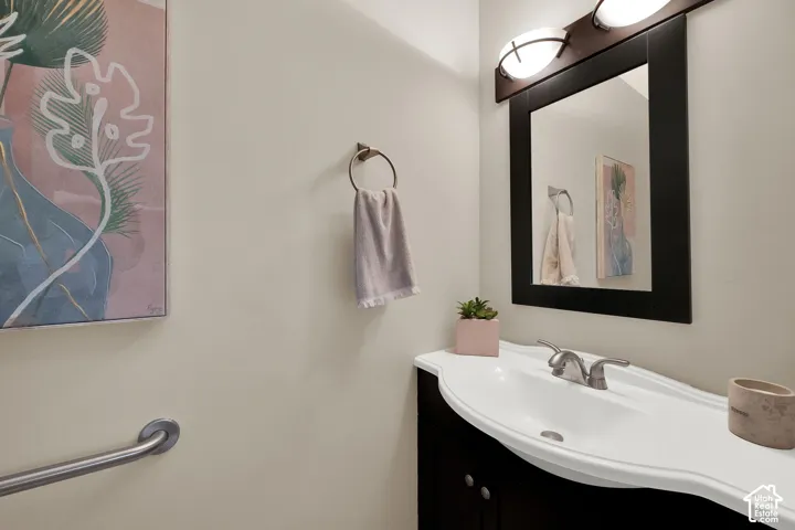 Guest Bath- Contemporary vanity featuring a curved white integrated sink and a dark wood-finish cabinet