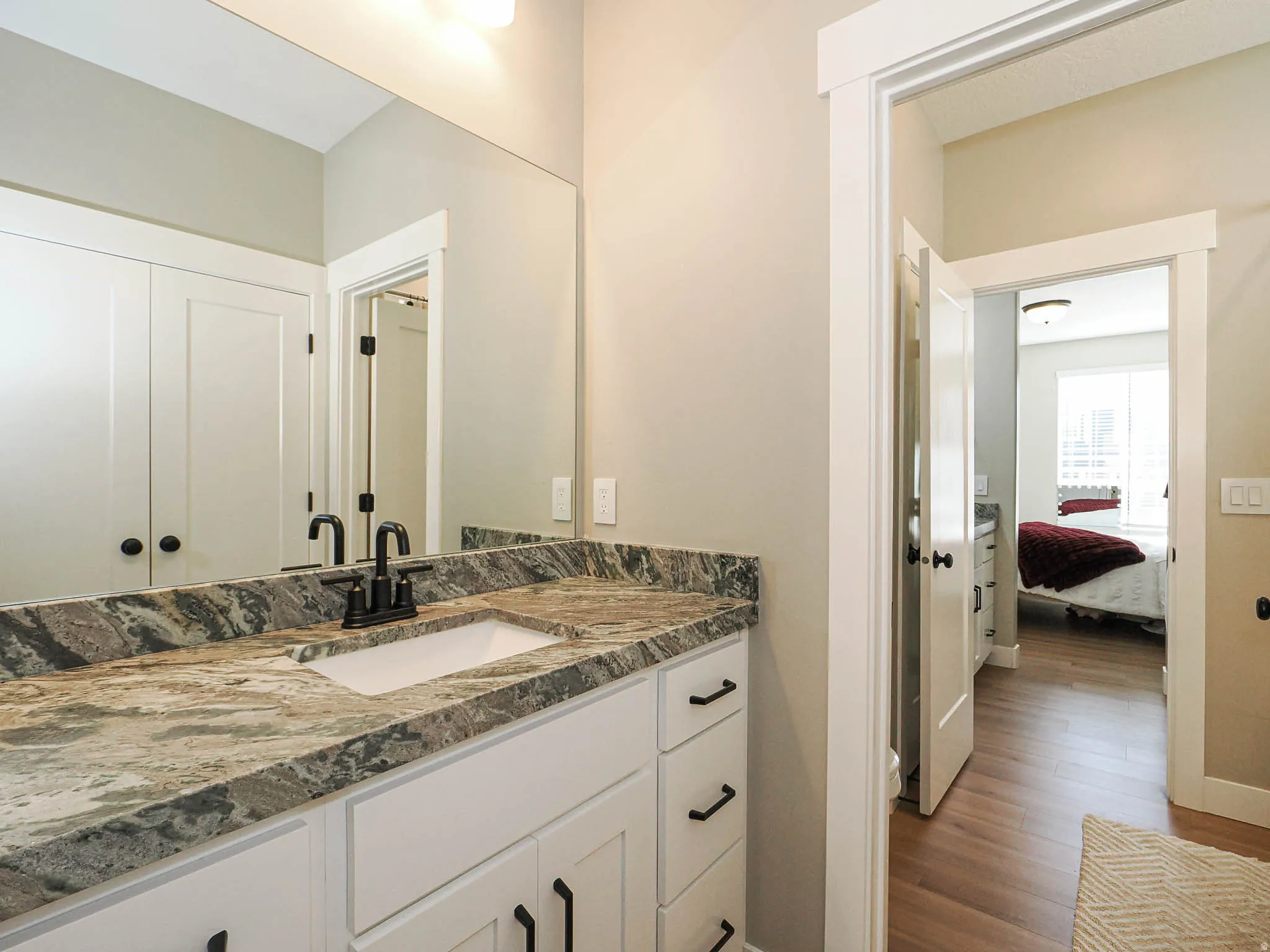 Bathroom vanity featuring a rectangular undermount sink, a patterned countertop, and a matte black faucet