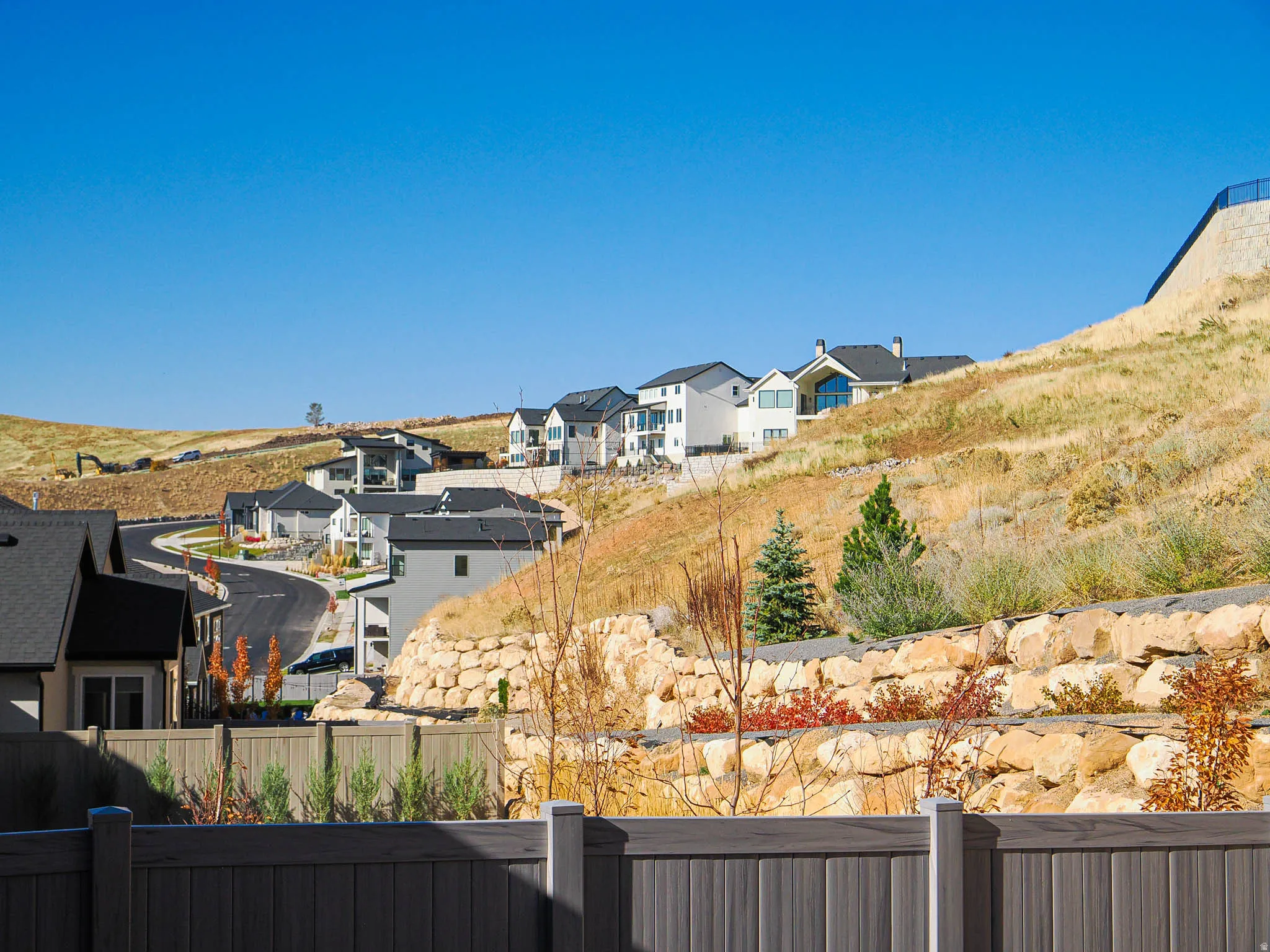 Hillside neighborhood featuring a paved cul-de-sac and contemporary homes with dark roofs