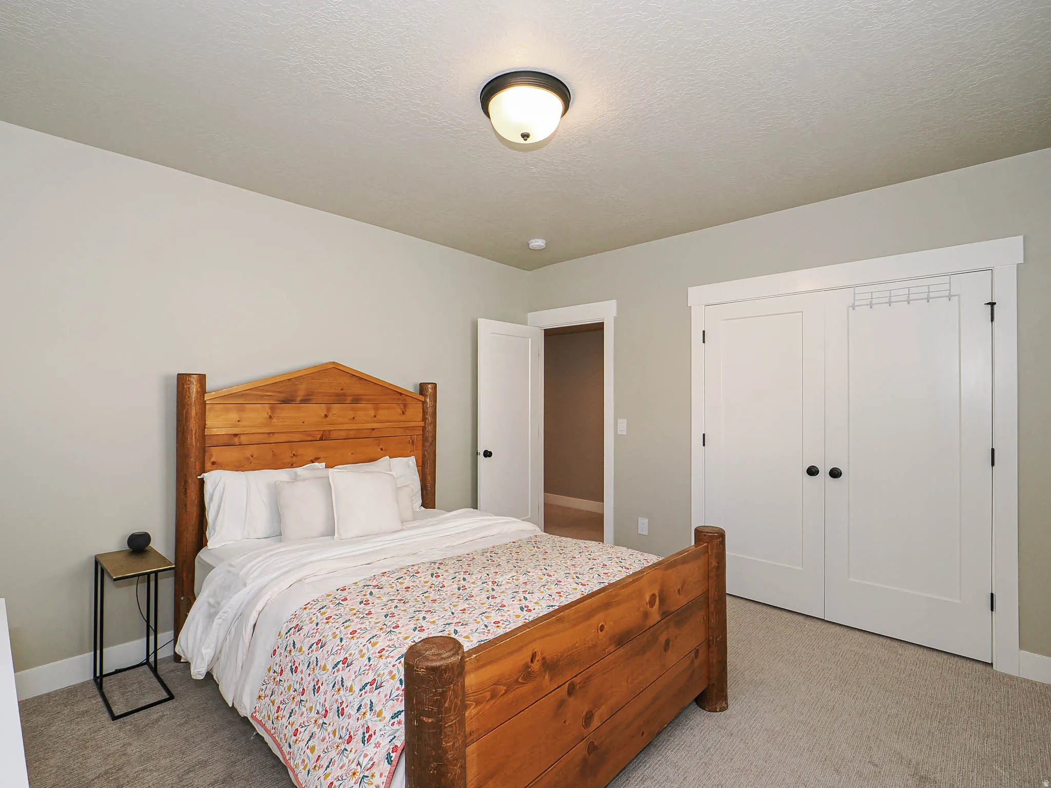 Carpeted bedroom featuring neutral wall tones and a ceiling-mounted light fixture