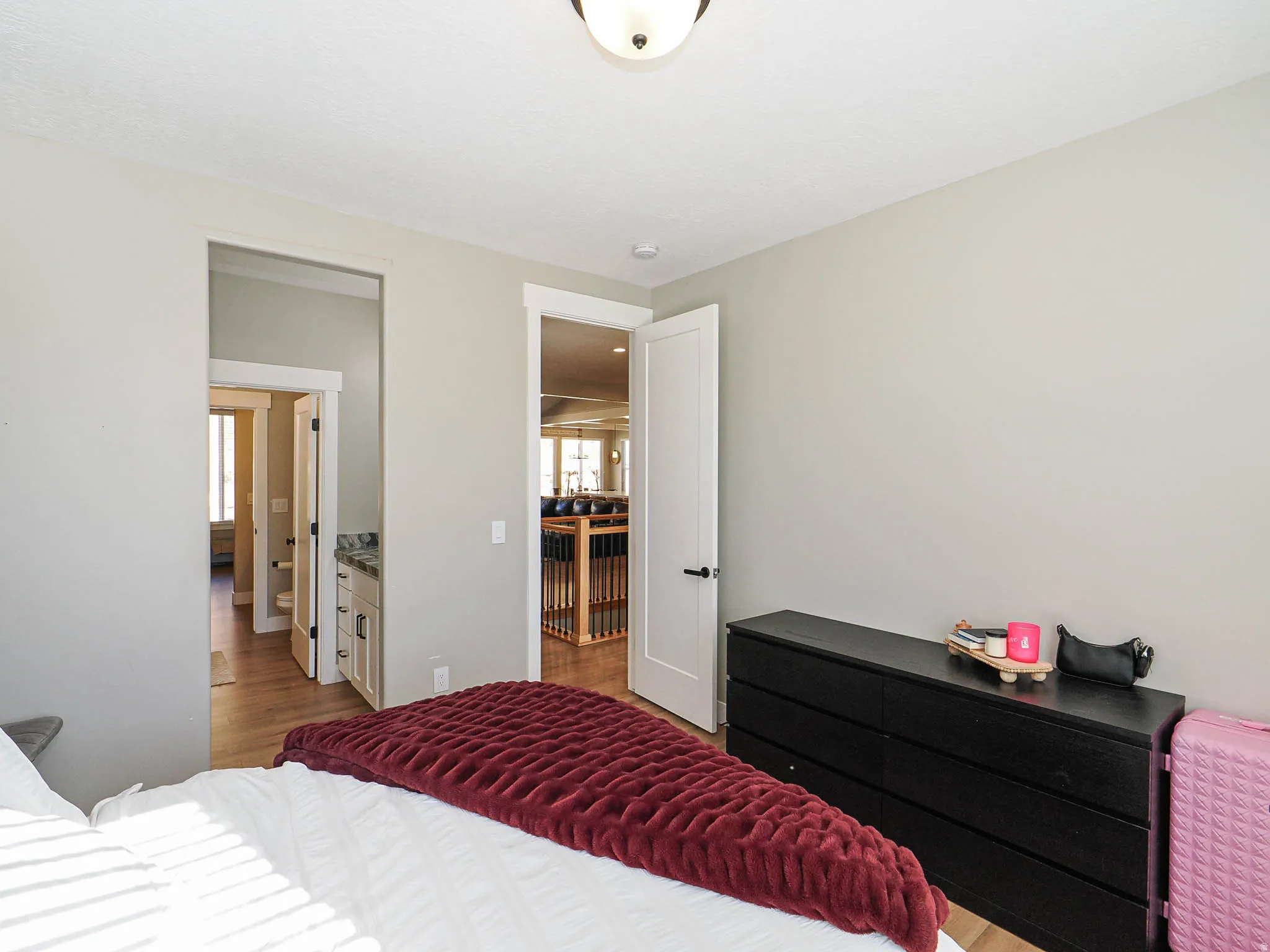 Bedroom featuring light gray walls, wood-finish flooring, a white ceiling, and a flush mount light fixture